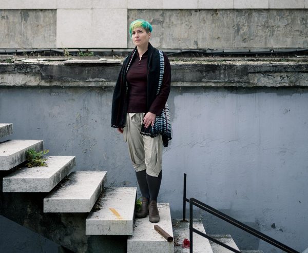 Artist Manu Luksch standing on concrete stairs