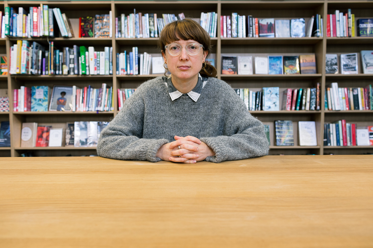 Artist Ruth Beale sitting at a desk in a library