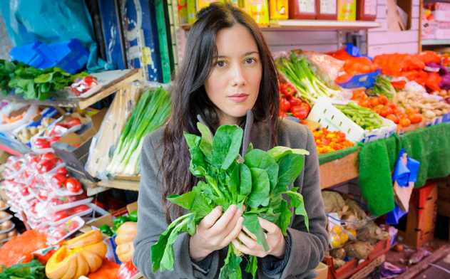 Artist Gayle Chong Kwan holding salad leaves in a outdoor market