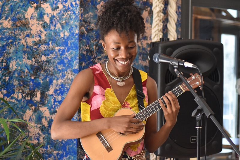 A woman playing guitar at the Message We Bring event